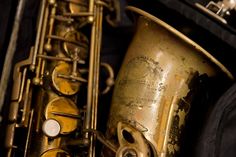 an old brass saxophone is sitting in its case