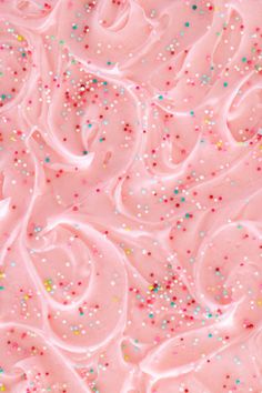 pink frosted cake with colorful sprinkles on it's edges and icing