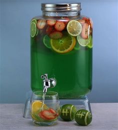 a pitcher filled with fruit and water on top of a table