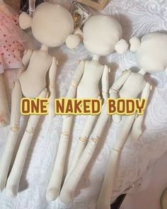 one naked body doll is laying next to other dolls