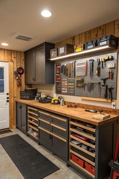 a workbench with lots of tools hanging on the wall next to a door