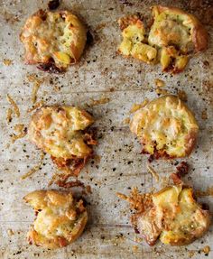 some food that is sitting on top of a baking sheet with grated cheese and other toppings