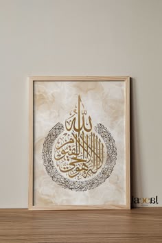 an arabic calligraphy is displayed in a wooden frame on a shelf next to a wall