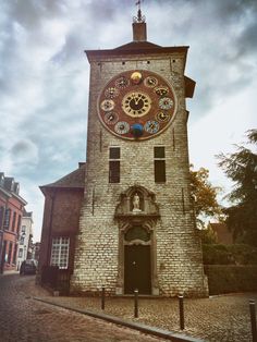 an old brick clock tower on a cobblestone street