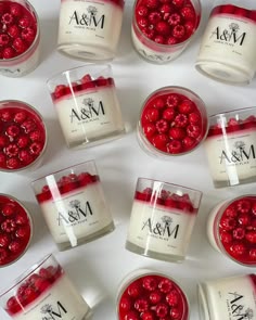 many candles with red berries in them on a table