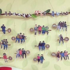 a group of people hanging from strings on a wall next to a red chair and table