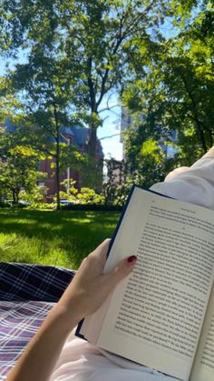 a person laying in a hammock with an open book on their lap while reading