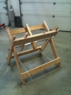 a wooden frame sitting on top of a floor in front of a garage door,