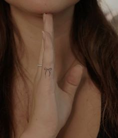 a woman with a bow tattoo on her finger