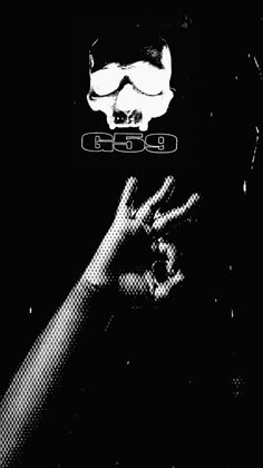 a black and white photo of a person with their hand up in the air while wearing goggles