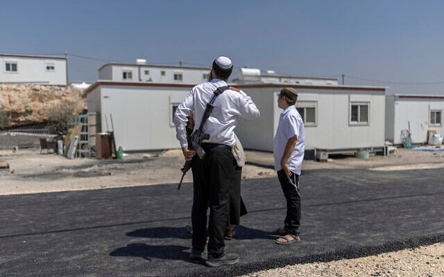 Israeli settlers stand outside houses after the reopening of the settlement of Ganim in the West Bank on August 13, 2026. (ILIA YEFIMOVICH/AFP) Israeli settlers stand outside houses after the reopening of the settlement of Ganim in the West Bank on August 13, 2026. (ILIA YEFIMOVICH/AFP)