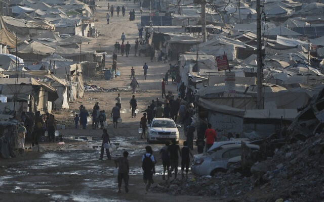Palestinians walk among tents and rubble on the coastal road in Gaza City, in the Strip's north, on August 13, 2026. (AP Photo/Abdel Kareem Hana) Palestinians walk among tents and rubble on the coastal road in Gaza City, in the Strip's north, on August 13, 2026. (AP Photo/Abdel Kareem Hana)